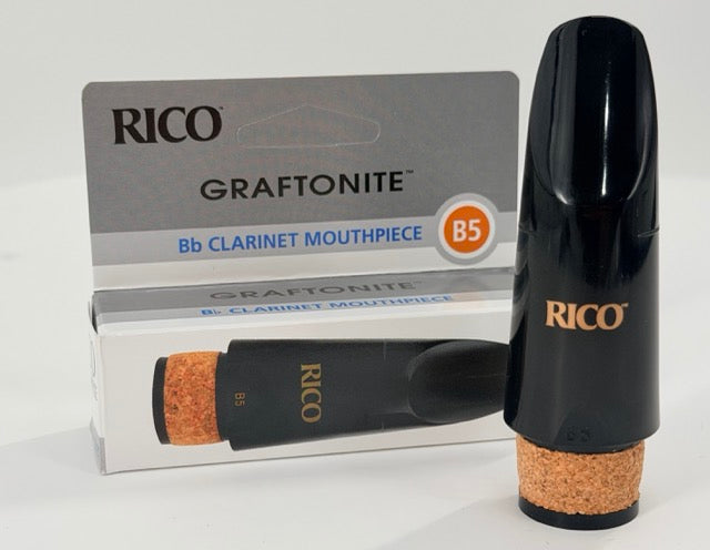 A Rico Graftonite B5 Bb Clarinet Mouthpiece stands upright in front of its box, prominently displaying the brand name and model.