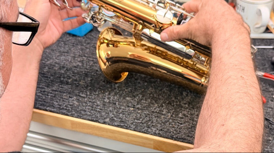 A repair tech working on an alto saxophone in our Norwalk, CT facilty